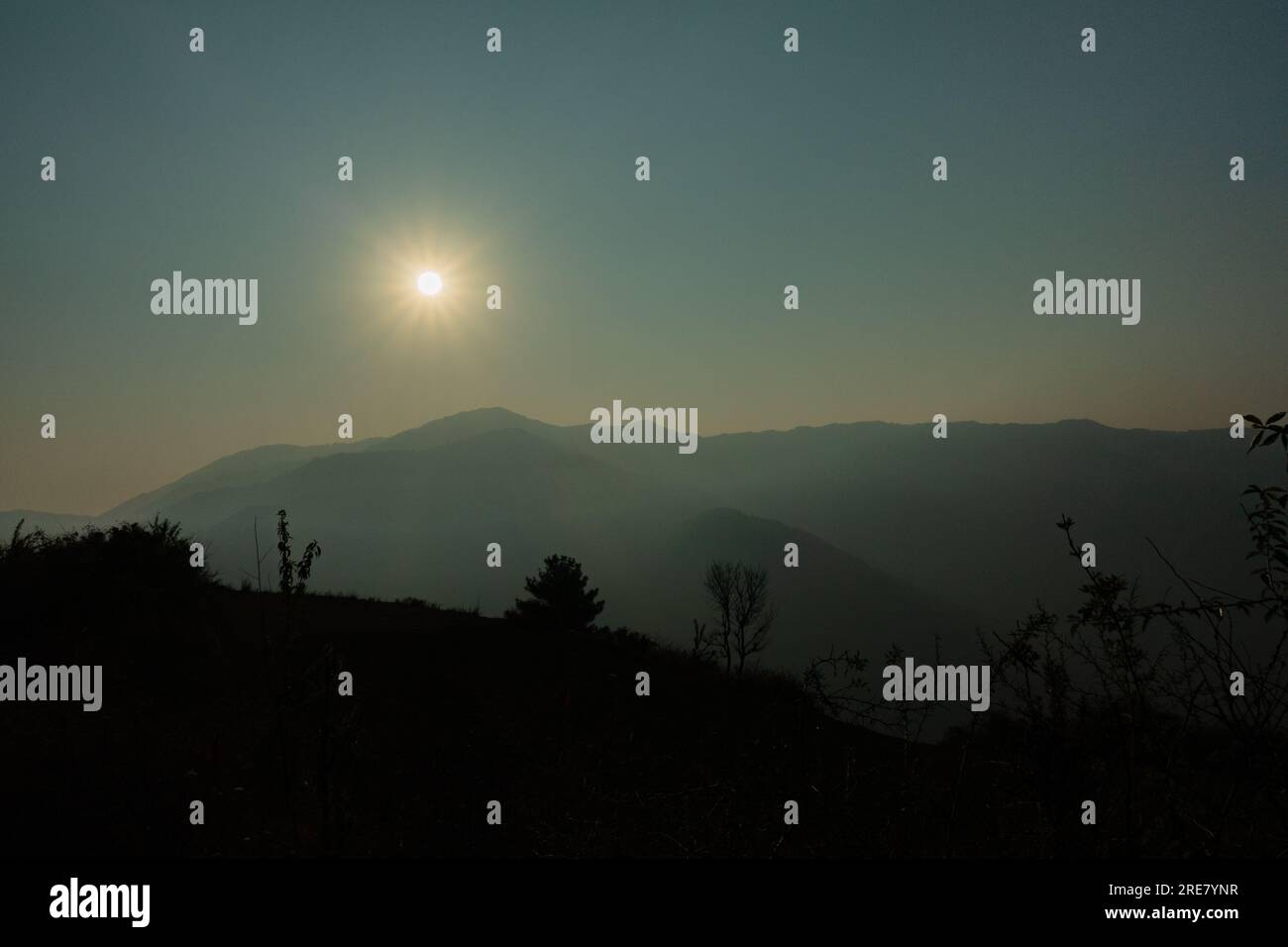 Die Morgensonne scheint auf den NAAG Tibba Mountain in Uttarakhand, Indien, und schafft eine trübe Atmosphäre, die eine trübe Atmosphäre schafft. Stockfoto