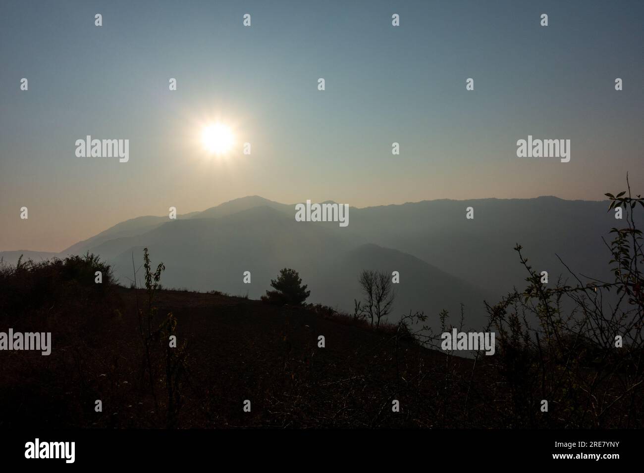 Die Morgensonne scheint auf den NAAG Tibba Mountain in Uttarakhand, Indien, und schafft eine trübe Atmosphäre, die eine trübe Atmosphäre schafft. Stockfoto