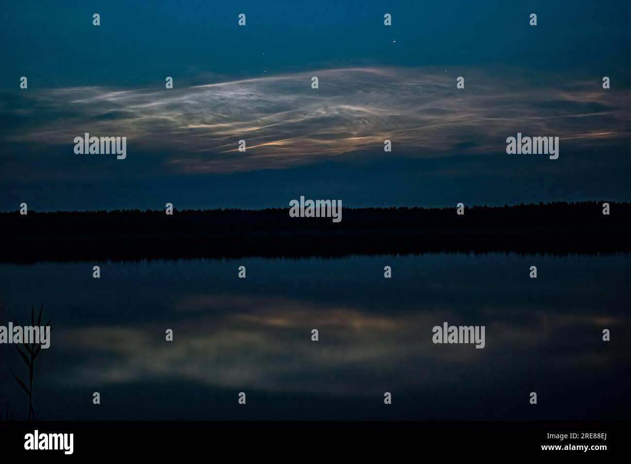 Nächtliche Wolken oder nachts leuchtende Wolken im Spiegel des Sees. Stockfoto