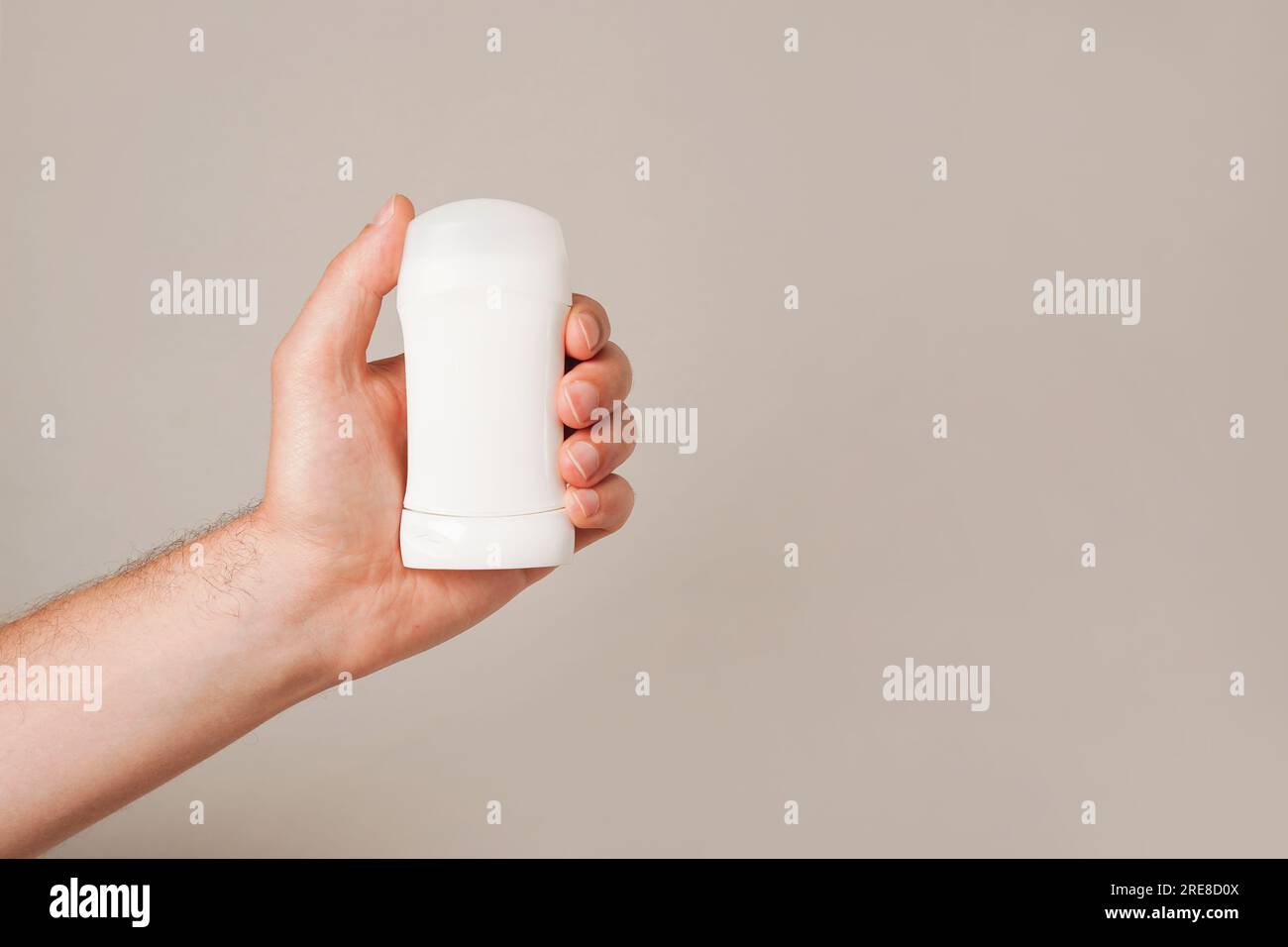 Männliche Hand mit weißem Deodorant auf grauem Hintergrund. Nahaufnahme. Speicherplatz kopieren Stockfoto