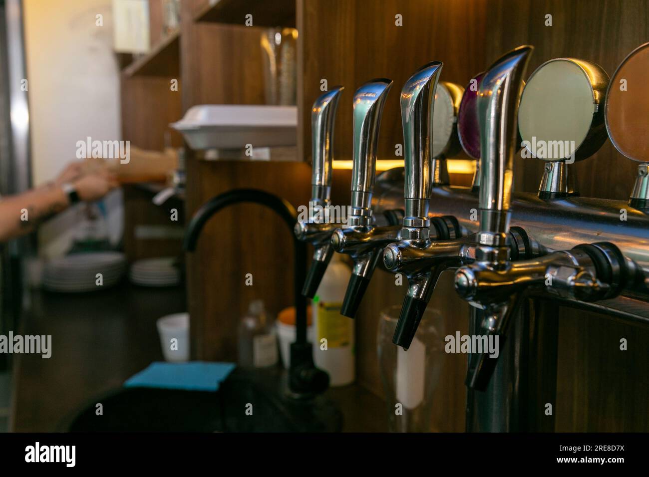 Verchromte Zapfhähne für Fassbier in einer modernen Bar. Detail der Biermaschine, Bierspender, Nahaufnahme, selektiver Fokus, Retro-Stil Stockfoto