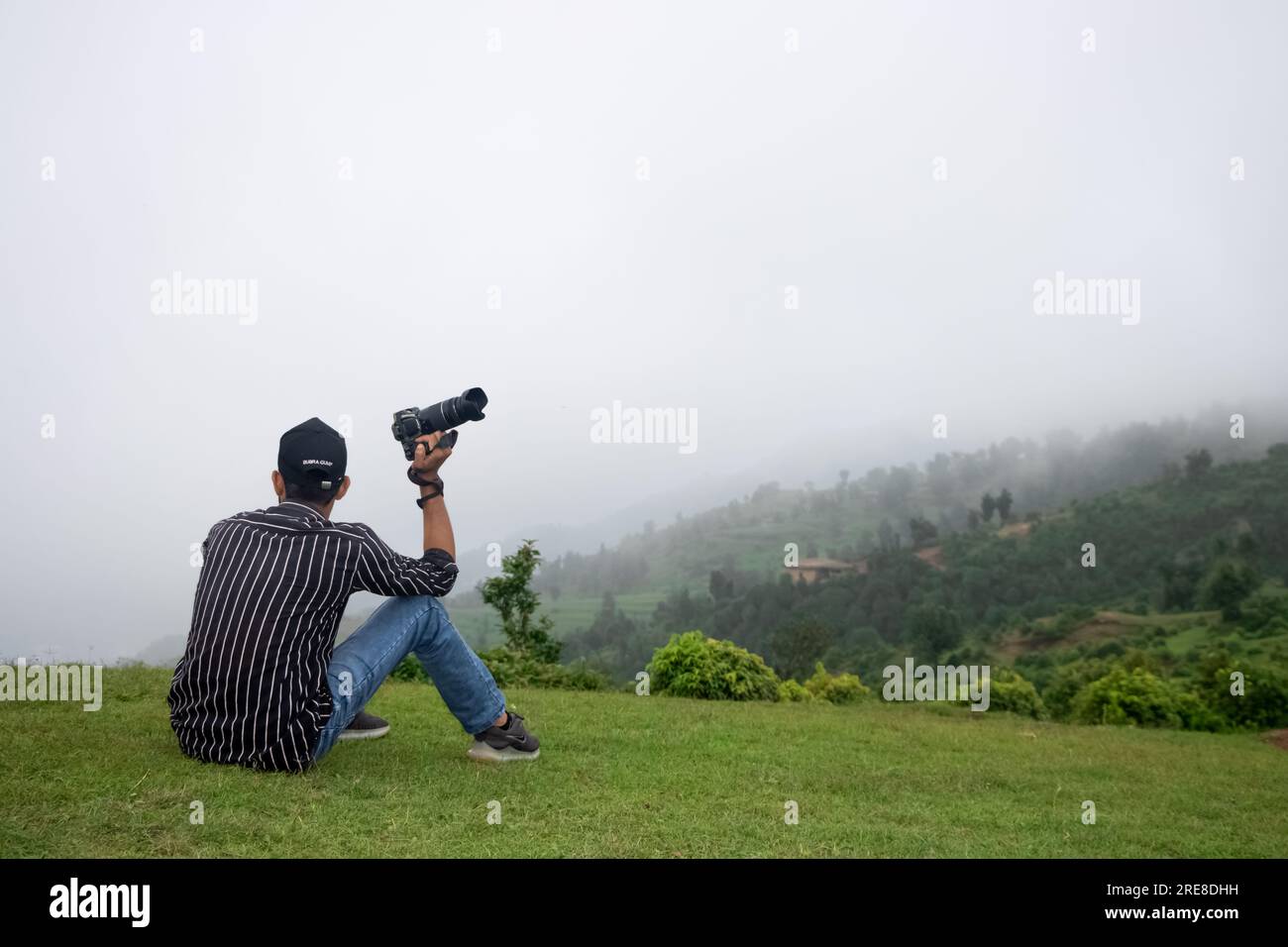 Ein Fotograf hält die Kamera in der Hand auf dem Gipfel des Himalaya Berges und fühlt sich entspannt und genießt Momente... mit wunderschönem Landschaftsblick Stockfoto