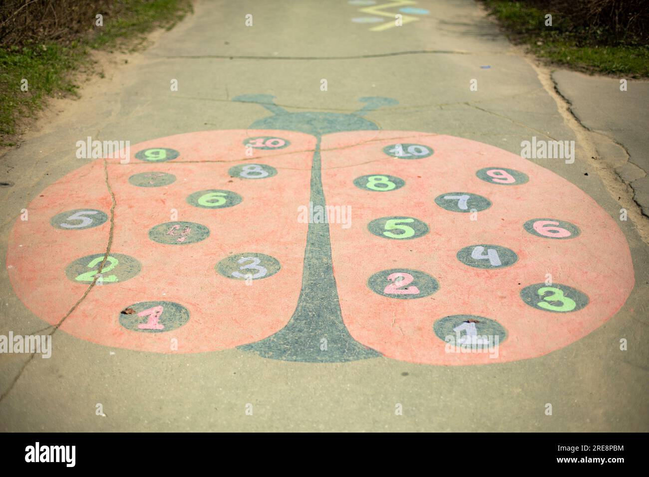 Auf Asphalt zeichnen. Marienkäfer auf dem Spielplatz gemalt. Kinderspiel. Stockfoto