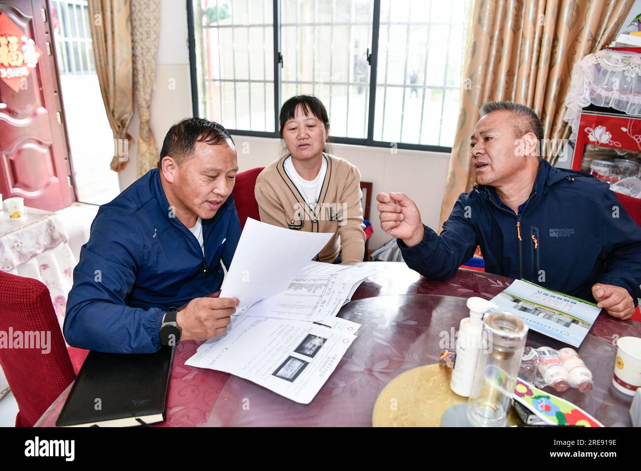 (230726) -- GUIYANG, 26. Juli 2023 (Xinhua) -- Zhu Daqing (L) prüft den medizinischen Bericht eines Patienten im Dorf Xinshui, Mazha Stadt Yi-Hui-Miao Autonomer Bezirk Weining, Provinz Guizhou im Südwesten Chinas, 19. Juli 2023. Zhu Daqing ist Landarzt im Dorf Xinshui, Mazha Stadt Yi-Hui-Miao Autonomer Kreis Weining. Zhu Daqing wurde in einer Familie mit Generationen von Ärzten geboren und war fest entschlossen, schon in jungen Jahren Arzt wie sein Vater zu sein, obwohl er aufgrund angeborener Abwesenheit der oberen Extremität im linken Unterarm behindert ist. Studierte traditionelle chinesische Medizin, Zhu Daqing schloss sein Studium ab Stockfoto