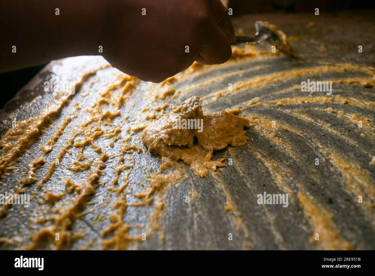 Zubereitung von peruanischem gelbem Chili, auch Aji-amarillo-Sauce genannt, mit einer vollen Mühle in der Stadt Cusco in Peru. Stockfoto