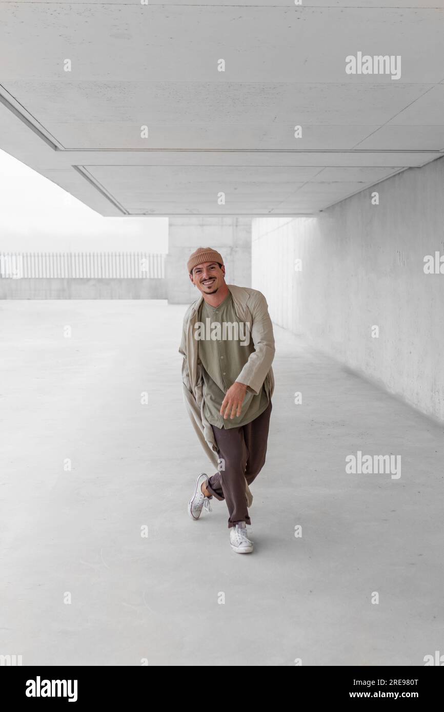 Seitenansicht eines talentierten männlichen Tänzers beim Breakdancing in einer geräumigen Passage Im Stadtgebiet Stockfoto
