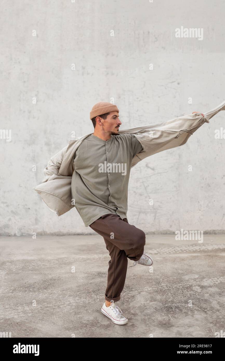 Seitenansicht eines talentierten männlichen Tänzers beim Breakdancing in einer geräumigen Passage Im Stadtgebiet Stockfoto