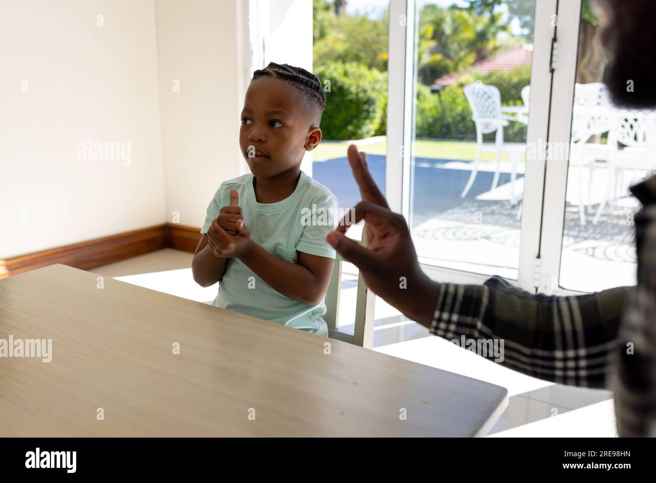 Glücklicher afroamerikanischer Vater und Sohn, die zu Hause Gebärdensprache praktizieren Stockfoto