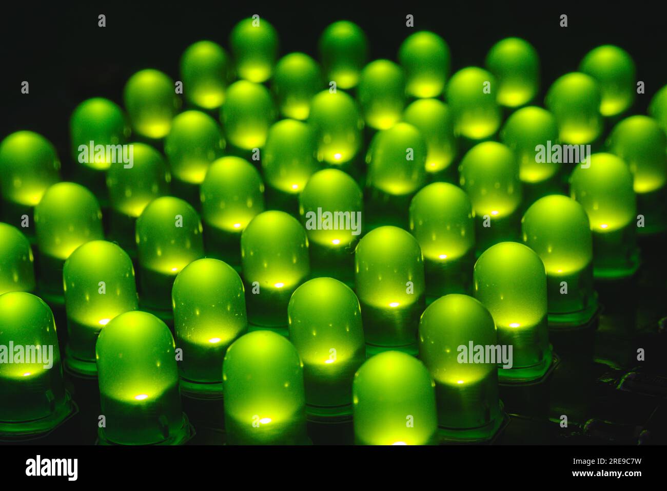 Nahaufnahme mehrerer leds durch Loch die grüne Farbe auf dem Tisch im abgedunkelten Raum Stockfoto