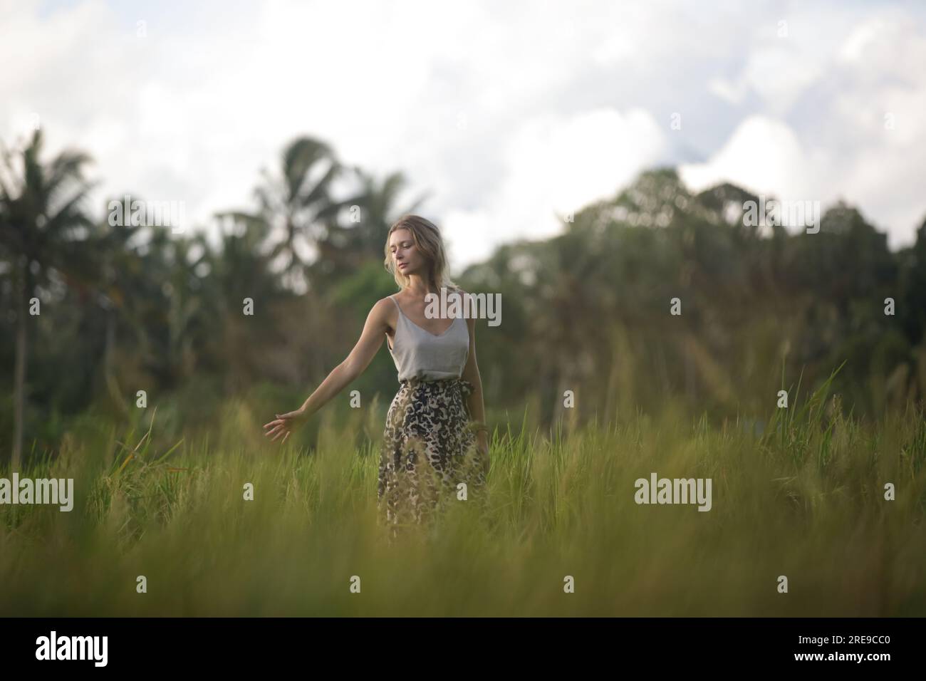 Outdoor-Modeporträt einer jungen Frau auf dem Reisfeld der tropischen Insel, natürliches Sonnenlicht. Konzept von Freiheit, Reisen, Umwelt, Verbindung Stockfoto