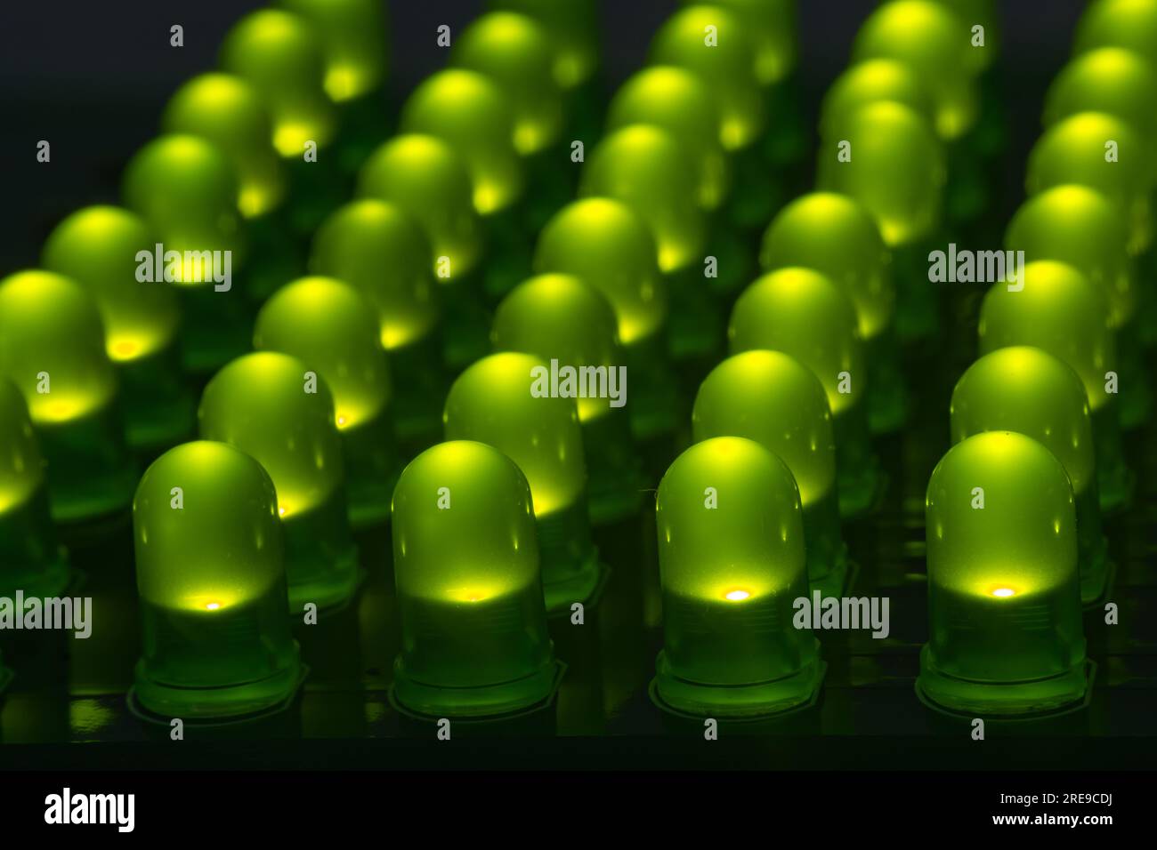 Nahaufnahme mehrerer leds durch Loch die grüne Farbe auf dem Tisch im abgedunkelten Raum Stockfoto