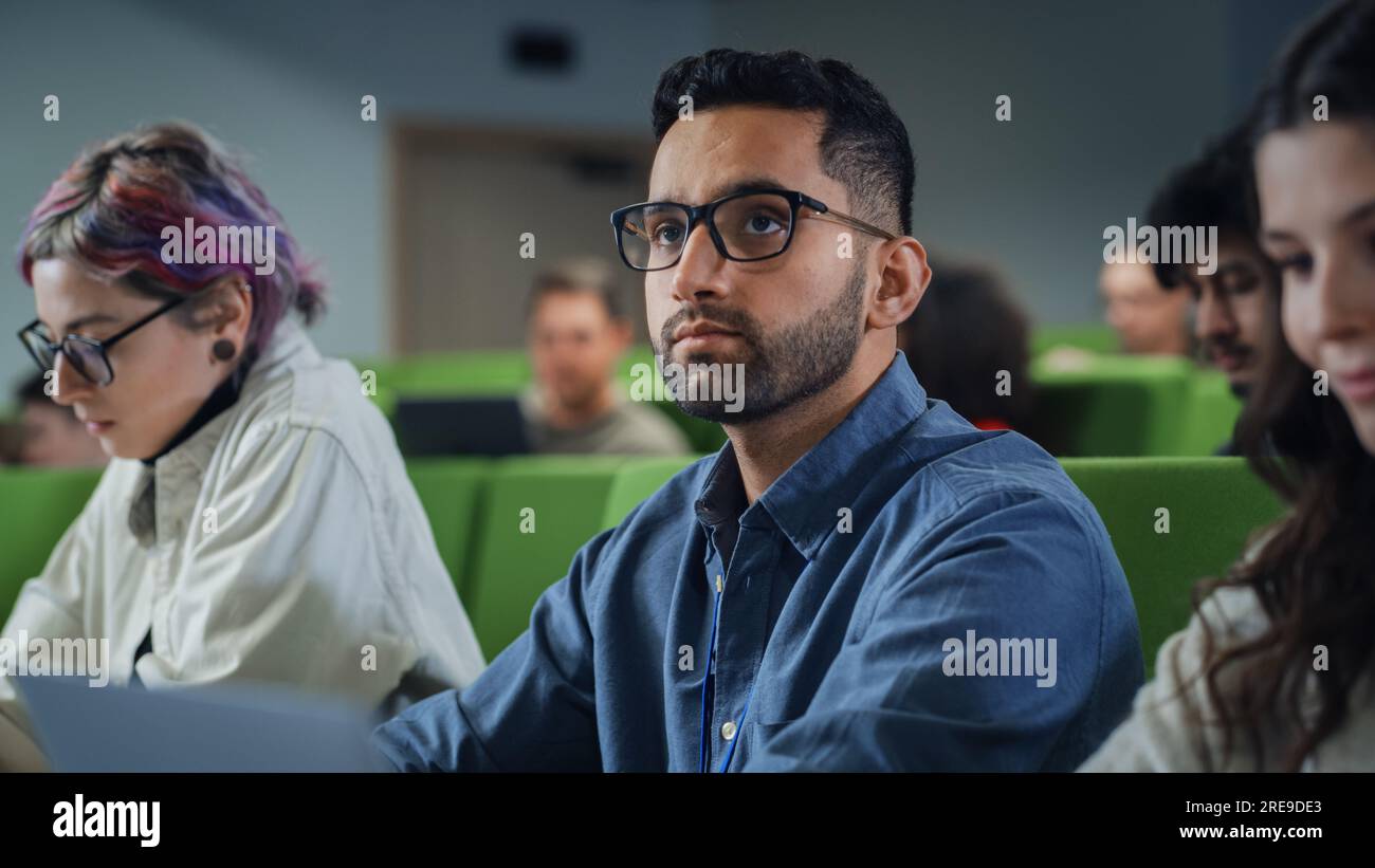 Nahaufnahme des Porträts eines kreativen Schülers in einer Vorlesung. Junge Person, die mit verschiedenen multiethnischen Klassenkameraden an der Universität studiert, nimmt an der Konferenz Teil Stockfoto