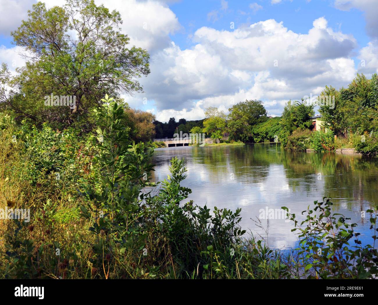 Wunderschöne Reflexionen aus Wolken und blauem Himmel spiegeln sich in den ruhigen Gewässern des Yahara River in Stoughton, Wisconsin, wider. Stockfoto