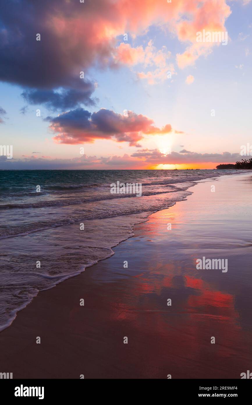 Farbenfroher Sonnenaufgang mit rosa Wolken am Himmel über der Atlantikküste, Bavaro Beach, Punta Cana. Dominikanische Republik Stockfoto