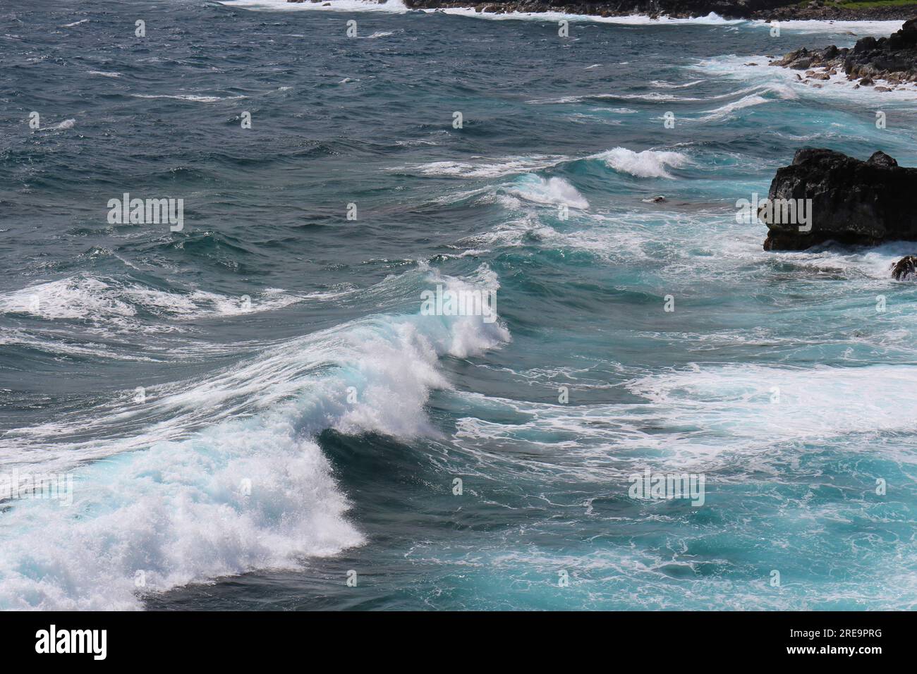 Kleine Wellen, die in die vulkanische Felsenküste in Wailuku, Maui, Hawaii, USA, eindringen Stockfoto
