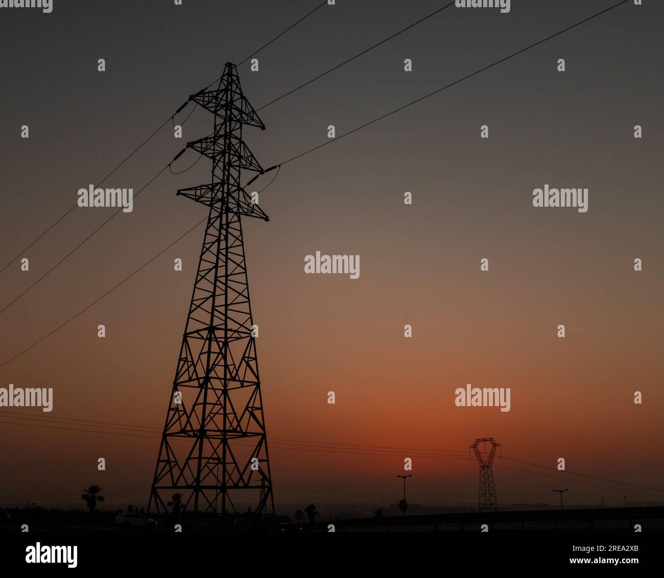 Der Schatten eines elektrischen Stabs während eines orangefarbenen Sonnenuntergangs Stockfoto