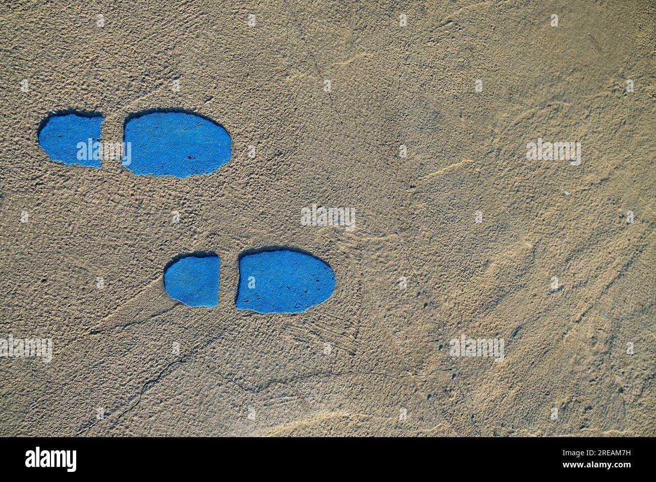 Zwei blaue Schuhpausen auf einem Betonpflaster. Stockfoto