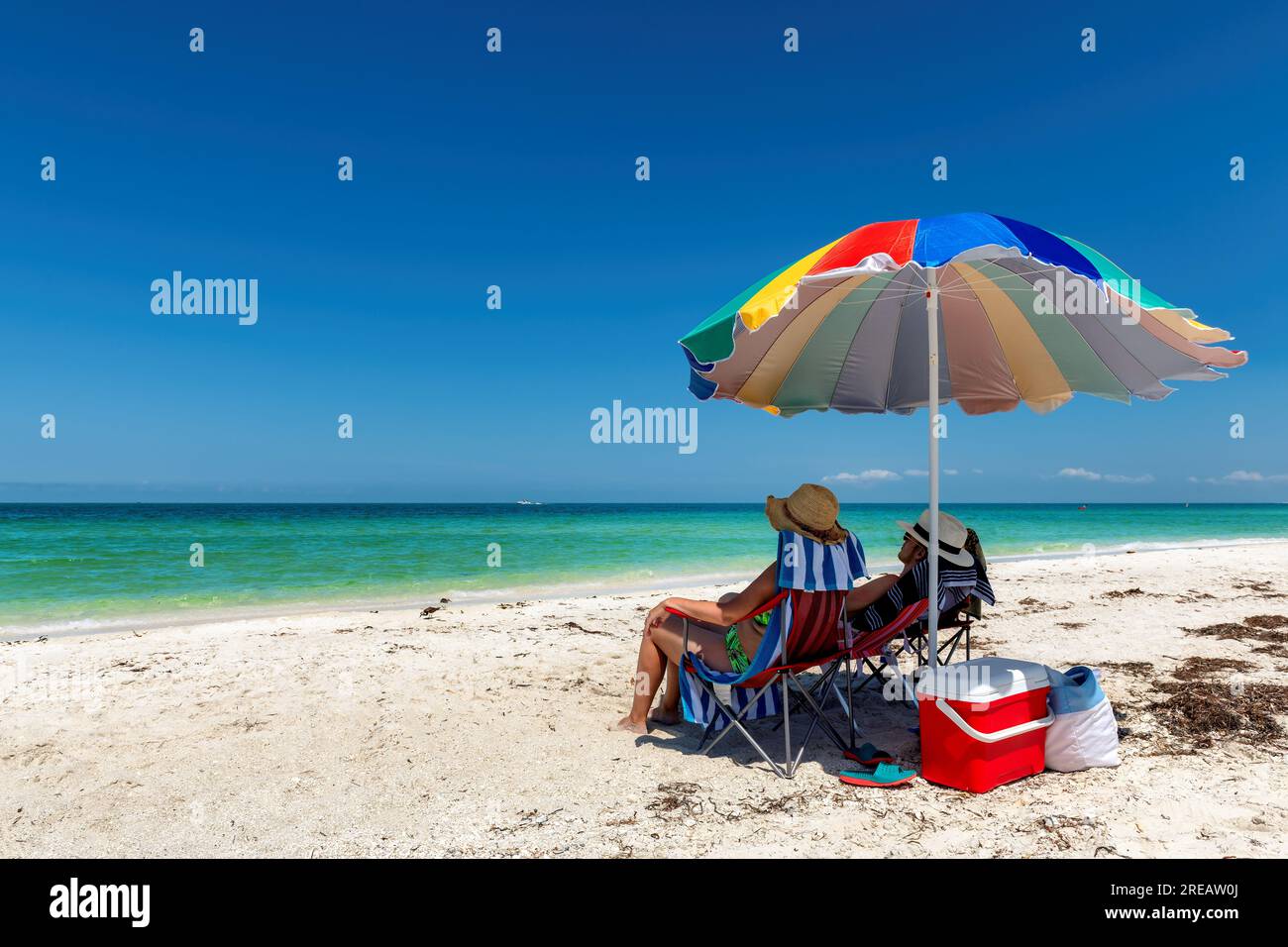 Sonniger Strand und tropisches Meer mit farbenfrohem Sonnenschirm Stockfoto Sonniger Strand und tropisches Meer mit farbenfrohem Sonnenschirm Stockfoto