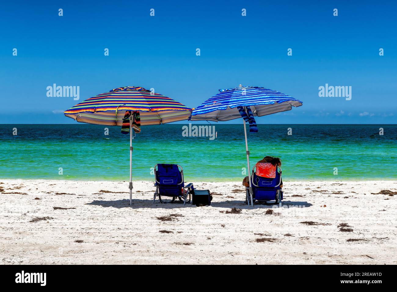 Sonniger Strand und tropisches Meer mit farbenfrohem Sonnenschirm Stockfoto Sonniger Strand und tropisches Meer mit farbenfrohem Sonnenschirm Stockfoto
