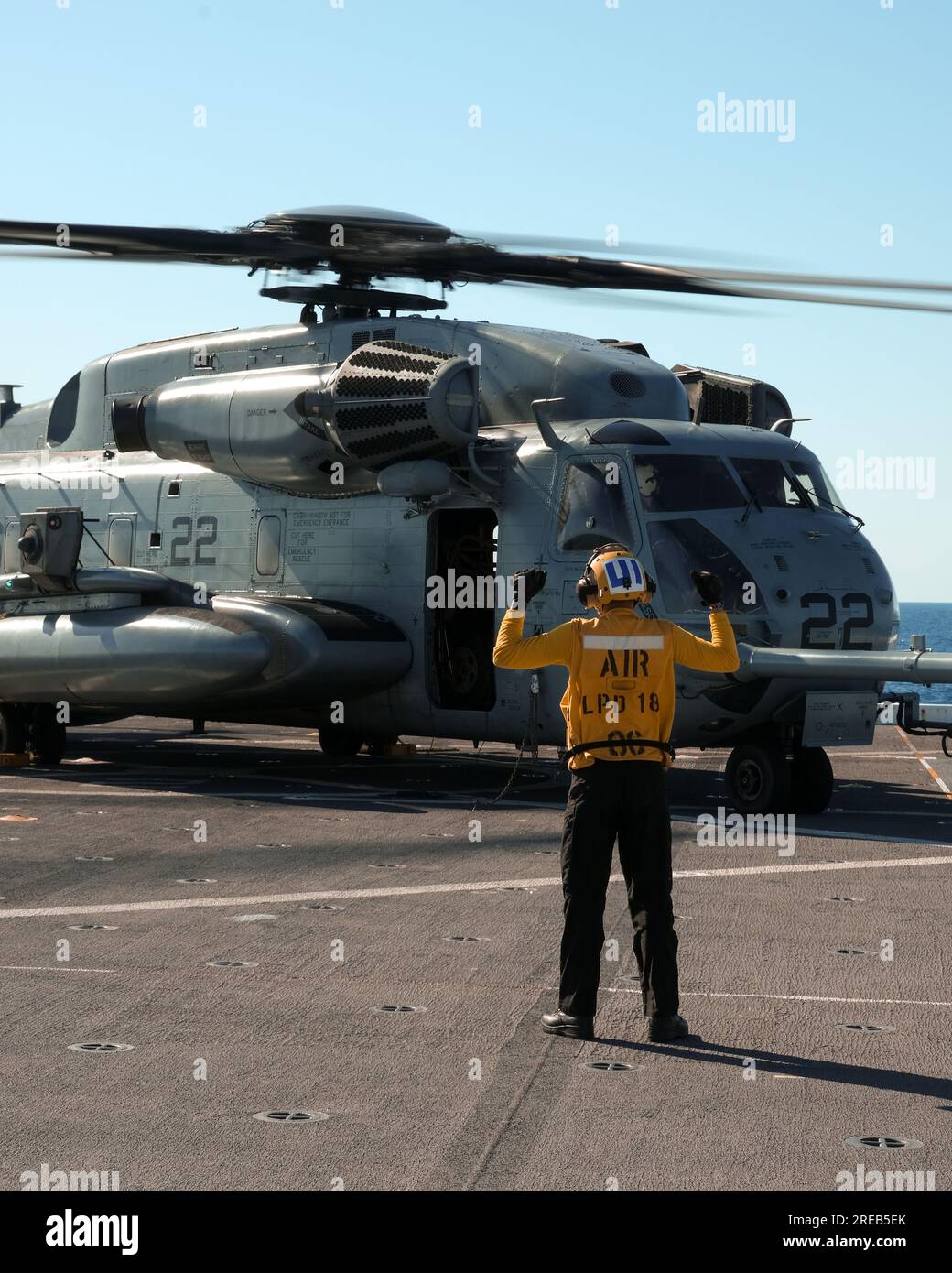 EIN US-AMERIKANISCHER Ein Navy Sailor, der dem Amphibienschiff USS New Orleans (LPD 18) zugewiesen ist, kommuniziert mit den USA per Handsignal Marines mit Marine Medium Tiltrotor Squadron 265 (rein.), während sie Flugbetrieb zur Vorbereitung auf Talisman Sabre 23 in der Korallensee, 23. Juli 2023. Die Fähigkeit, nahtlos und gleichzeitig auf dem Meer, an Land und in der Luft zu arbeiten, stellt den einzigartigen Wert amphibischer Kräfte dar. TS 23 ist die größte bilaterale Militäraktion zwischen Australien und den Vereinigten Staaten, die durch die Stärkung der Beziehungen ein freies und offenes Indo-Pacific vorantreibt Stockfoto