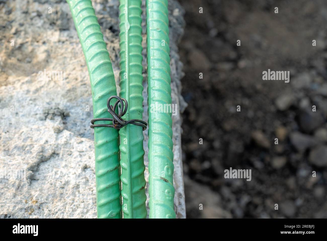 Epoxidbeschichteter Bewehrungsstahl wird in Beton verwendet, der korrosiven Bedingungen ausgesetzt ist. Dazu kann die Exposition gegenüber Enteisungssalzen oder Meeresumgebungen gehören. Stockfoto