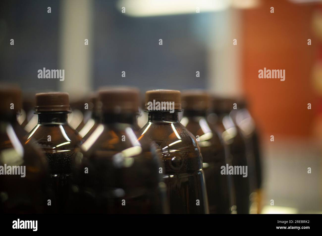 Flaschen kohlensäurehaltiges Getränk im Supermarkt. Wasser auf Lager. Kunststoffflaschen stehen in Reihe. Brauner Getränkebehälter. Stockfoto