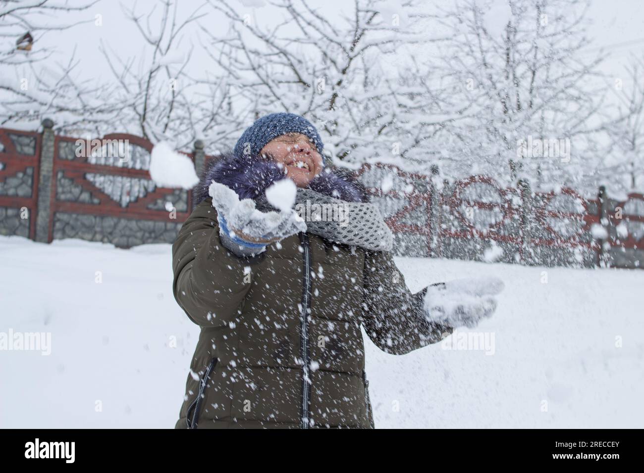 Eine Frau weicht dem Schneeball aus, frohe Winterspiele Stockfoto