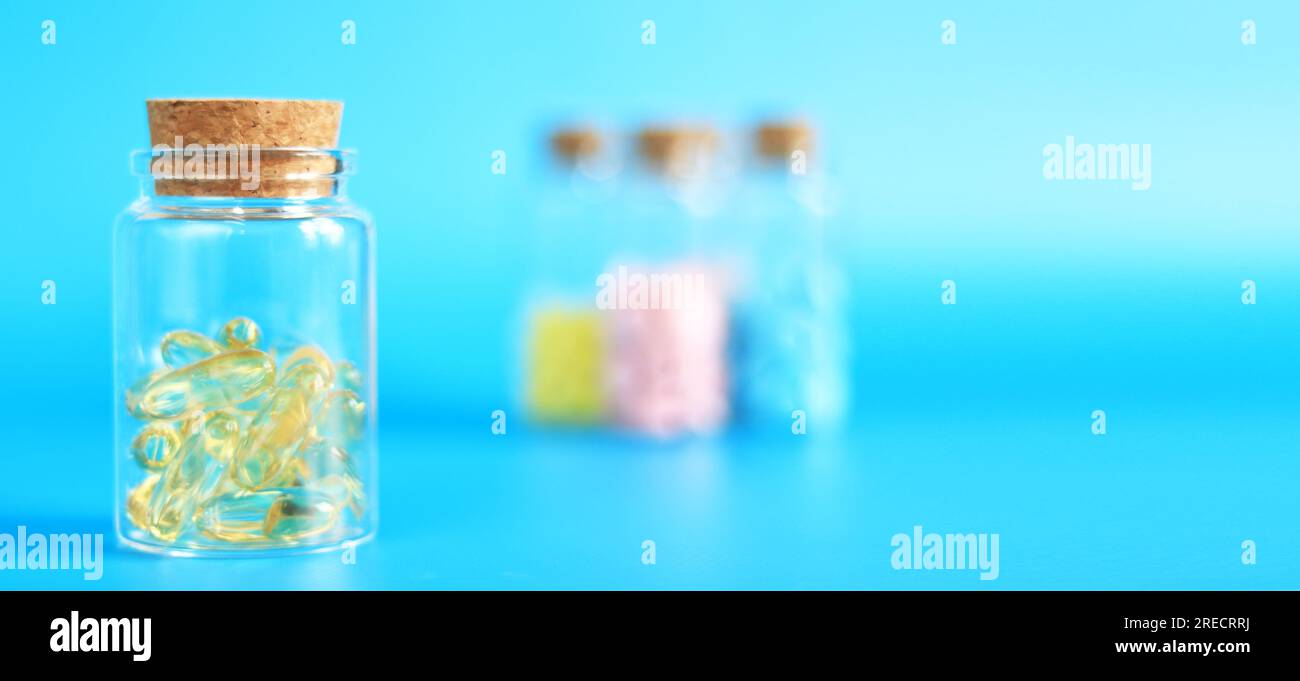 Omega 3 Kapseln in einer Glasflasche auf blauem Hintergrund. Gesundheitswesen, medizinische Pillen und Nahrungsergänzungsmittel. Gesundheitskonzept Stockfoto
