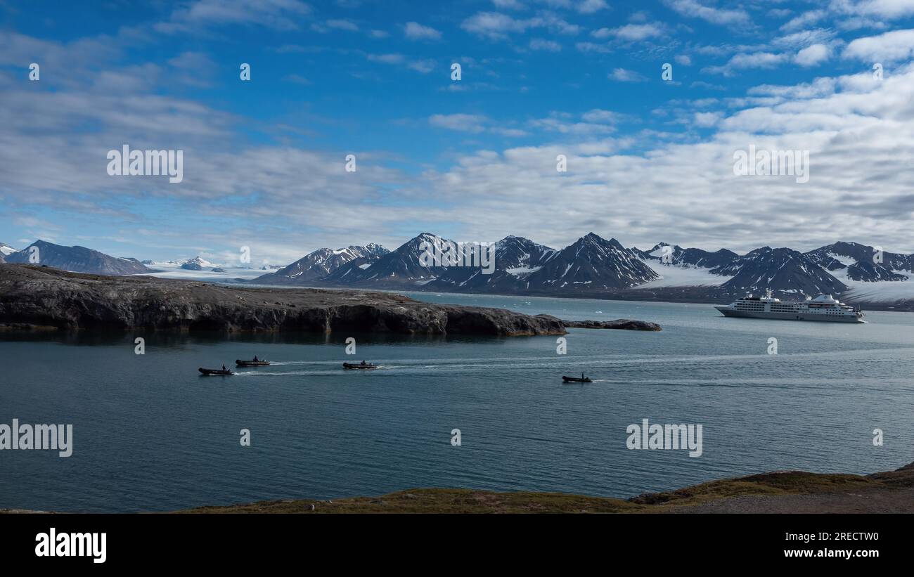 Umgeben von inaktiven Gletschern fahren Zodiaks aus dem Silberwinde nach Blomstrandøya, um sich auf eine Expedition nach NY-London vorzubereiten. Stockfoto