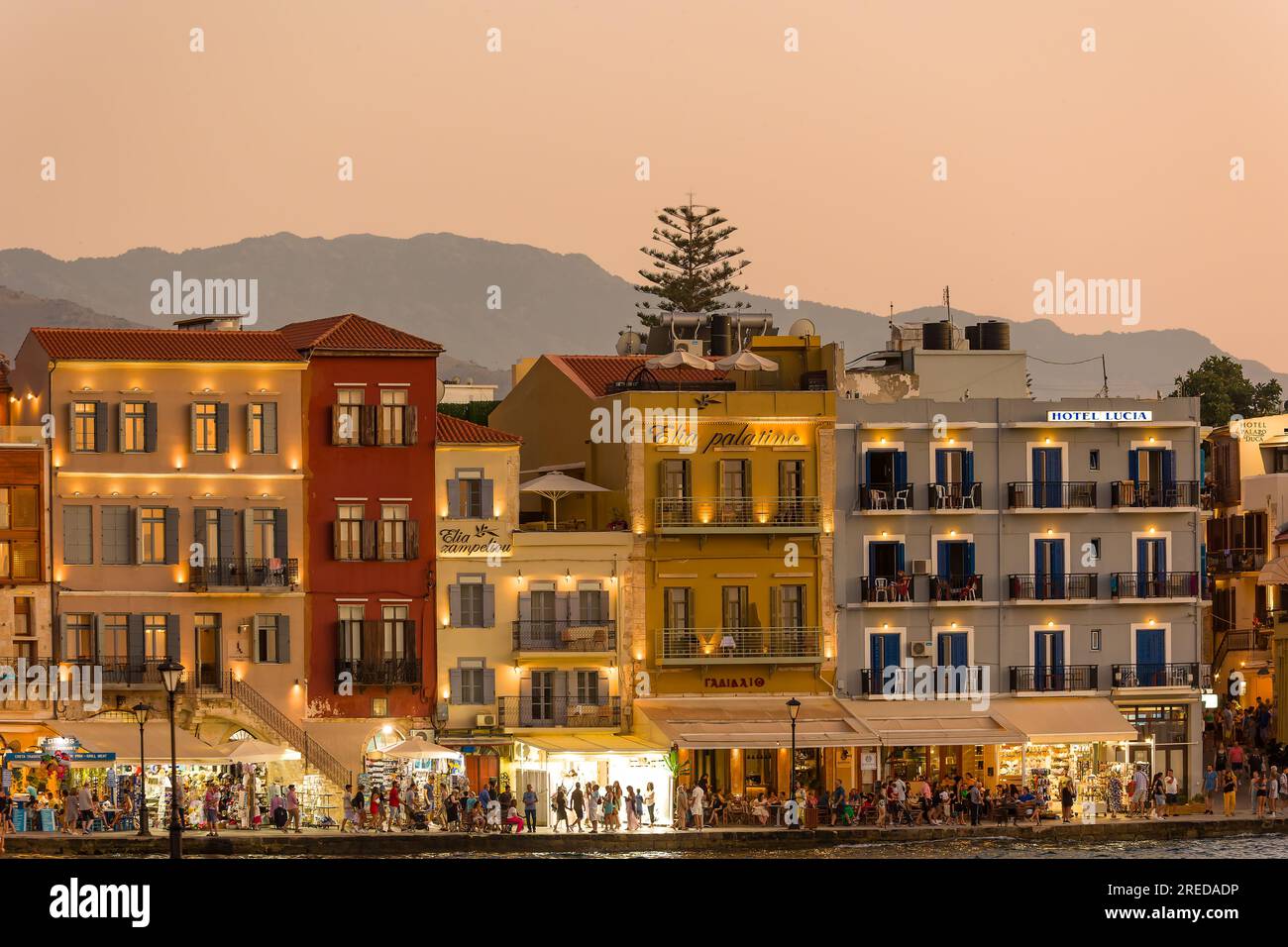 KRETA, GRIECHENLAND - JULI 03 2023: Abends treffen sich viele Touristen in Restaurants rund um den alten venezianischen Hafen von Chania im Westen Kretas Stockfoto
