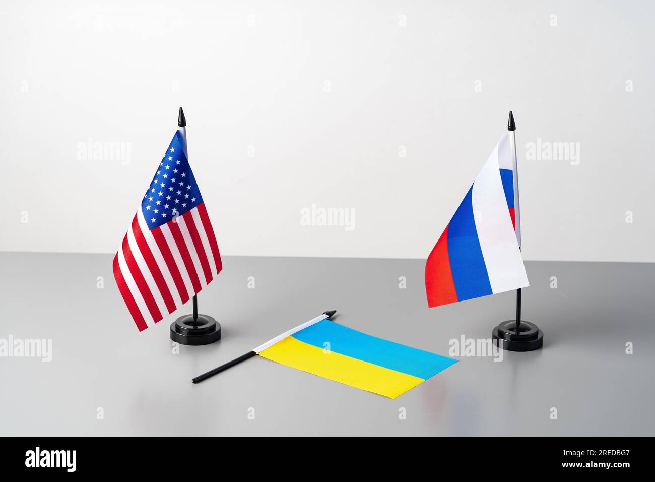 Flaggen der Ukraine, der USA und Russlands auf dem grauen Tisch Stockfoto
