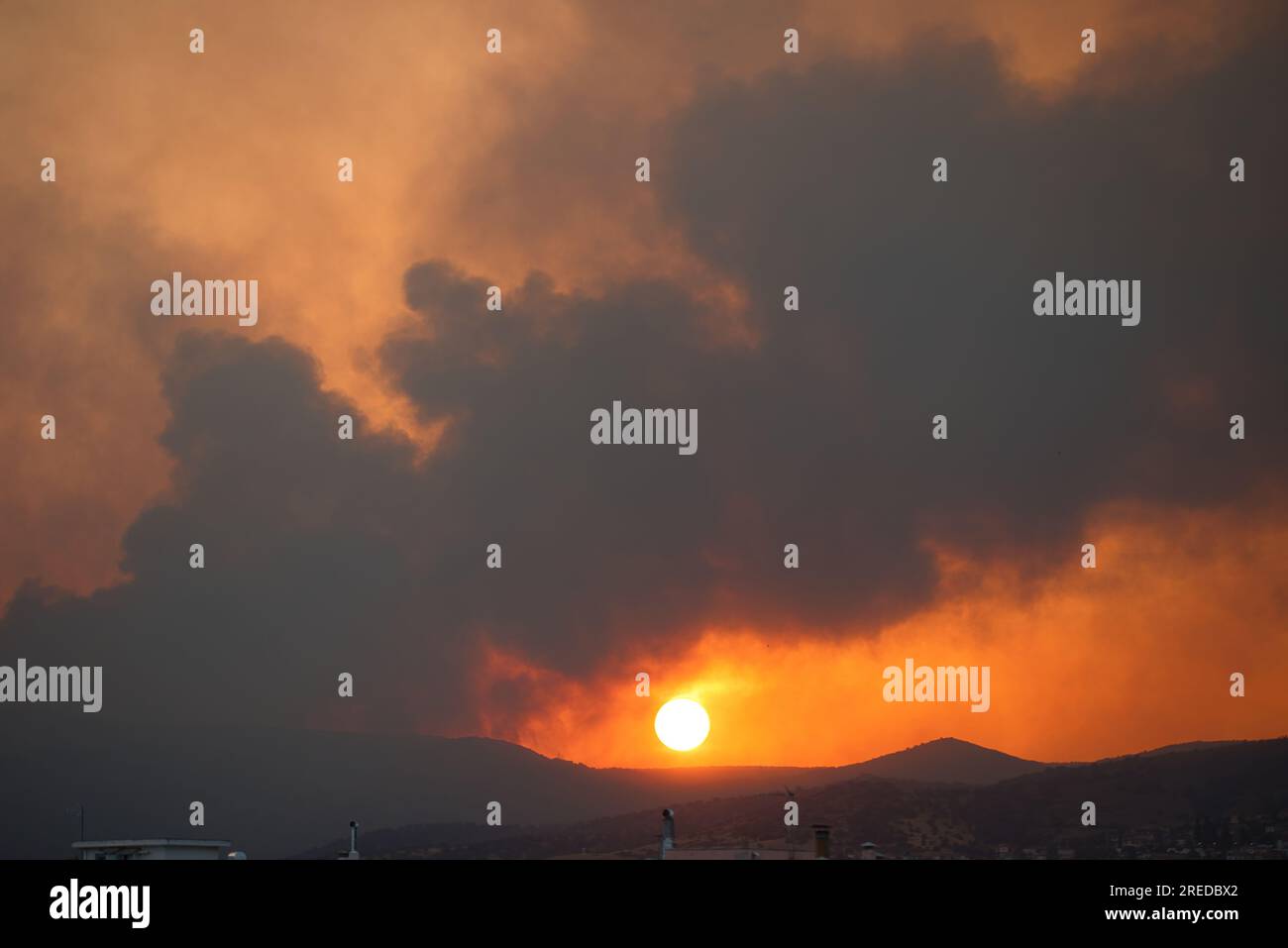 Feuer in der Nähe der Stadt, riesige Brandrauchwolke bei Sonnenuntergang, Volos, Griechenland, 26. Juli 2023 Stockfoto