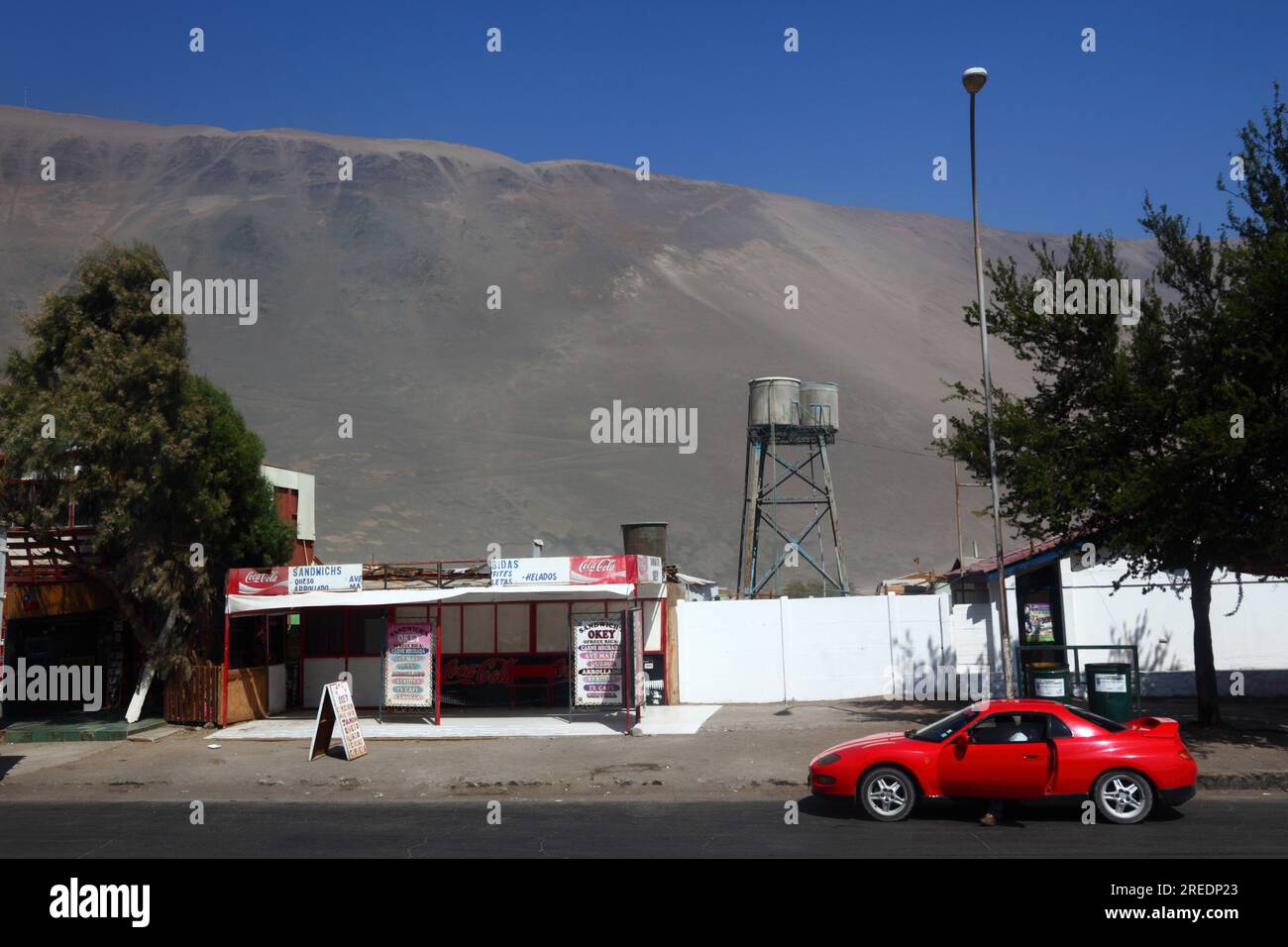 Roter Sportwagen neben dem Imbissstand am Zollkontrollposten auf der Panamerikanischen Autobahn Ruta 5, Cuya, Chile Stockfoto