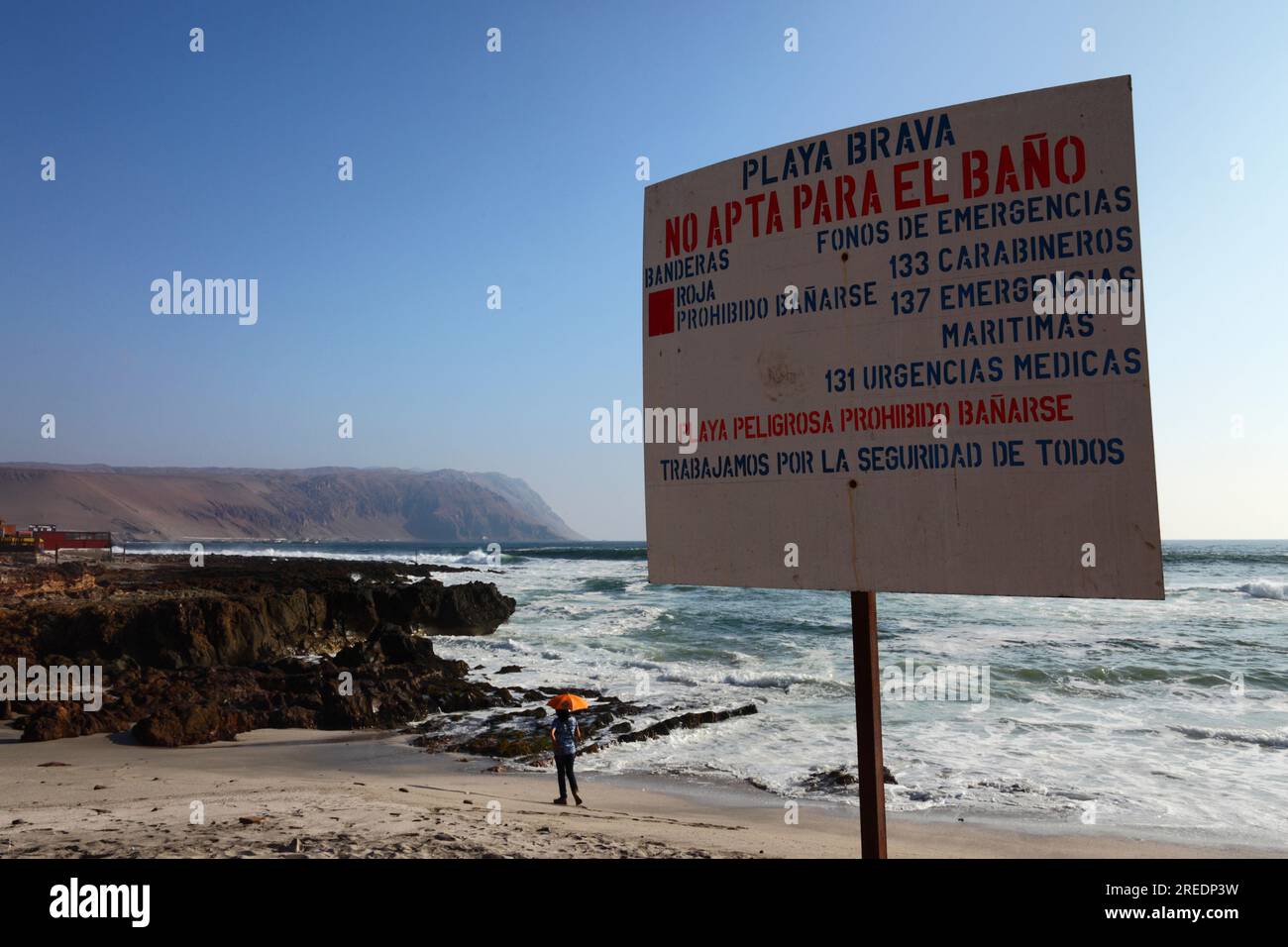 Gefährlicher Strand, Baden verboten Schild mit Notfallkontaktnummern in Playa Brava an der Pazifikküste südlich von Arica, Region XV, Chile Stockfoto