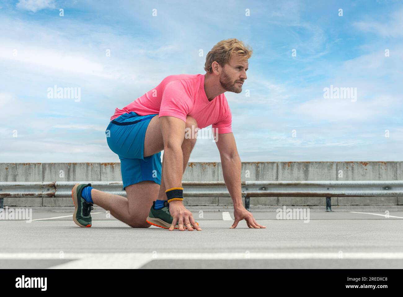 Fit Mann in Startposition, bereit für seinen Lauf Stockfoto