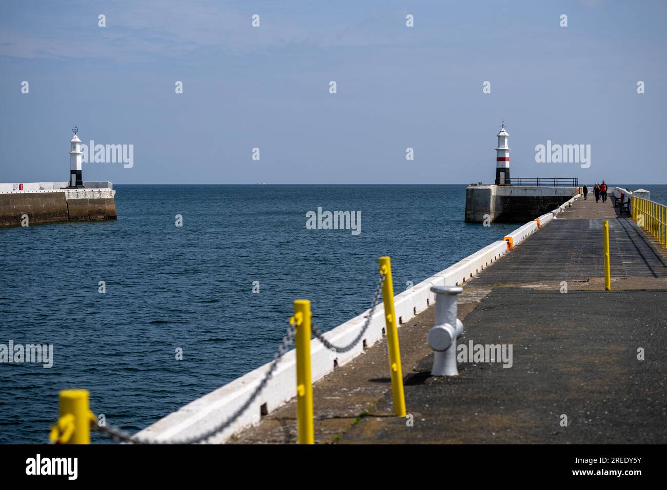 Der Leuchtturm und der Kai am Ramsey auf der Isle of man sorgen für einen angenehmen Spaziergang in der Frühlingssonne Stockfoto