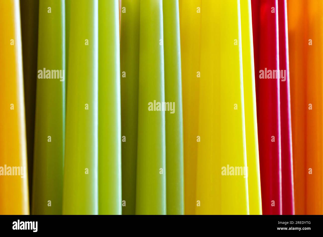 Große Gruppe von verschiedenen mehrfarbigen Wachskerzen, abstrakte parallele Linien, lebendiger Hintergrund Stockfoto