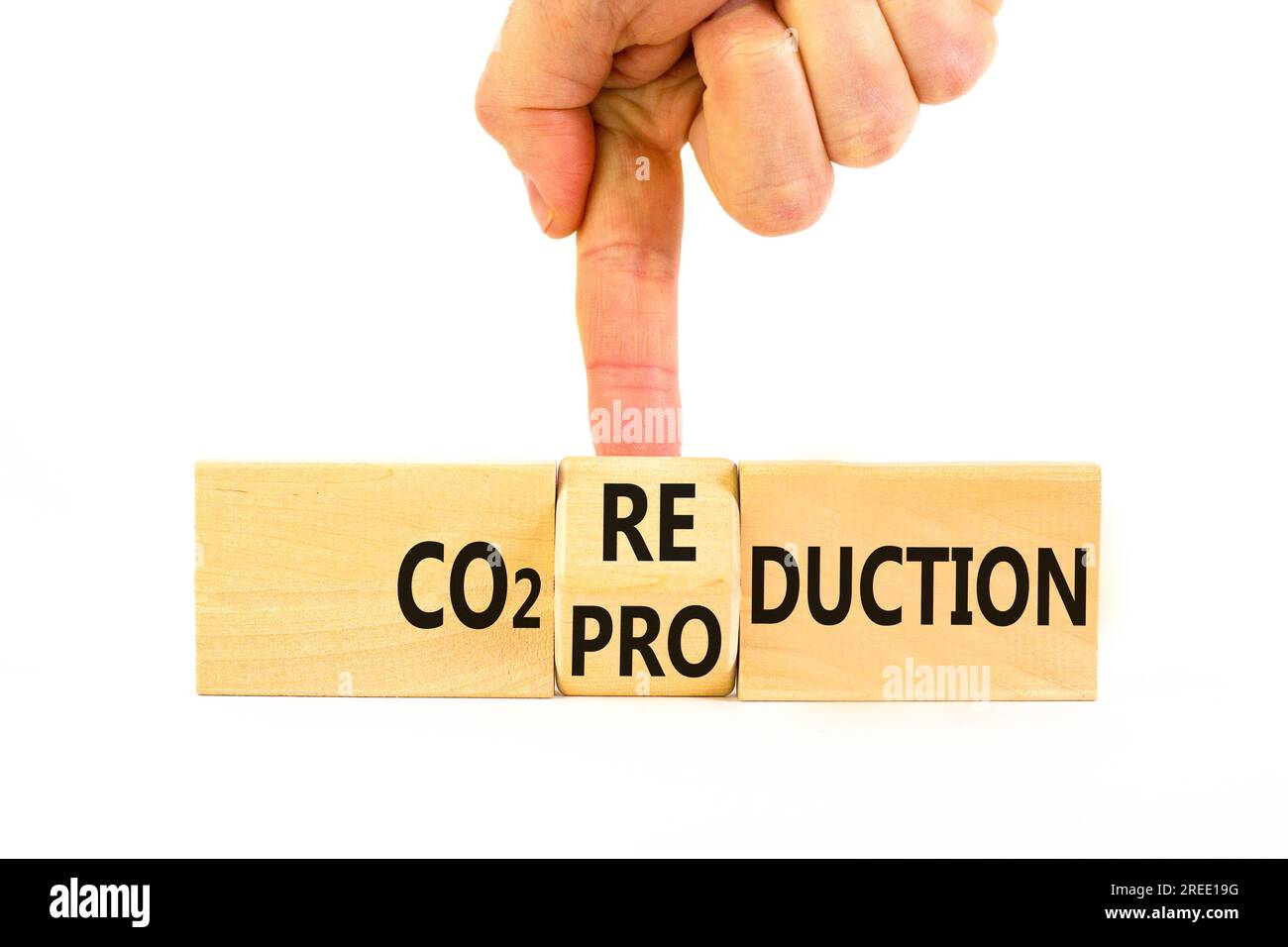 CO2 Symbol für Produktion oder Reduzierung. Konzeptwort CO2 Produktionsreduktion auf einem Holzblock auf einem wunderschönen weißen Hintergrund. Geschäftsmannshand. Geschäfte Stockfoto