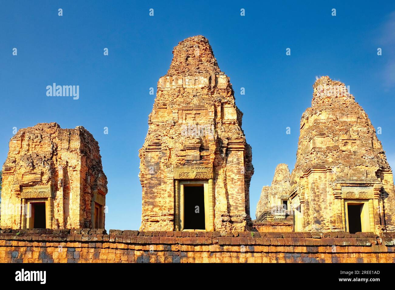 Hochauflösendes Bild, das die drei monumentalen Backsteintürme des Pre Rup Tempels einfängt, die stolz unter dem wolkenlosen blauen Himmel stehen und KHM reflektieren Stockfoto