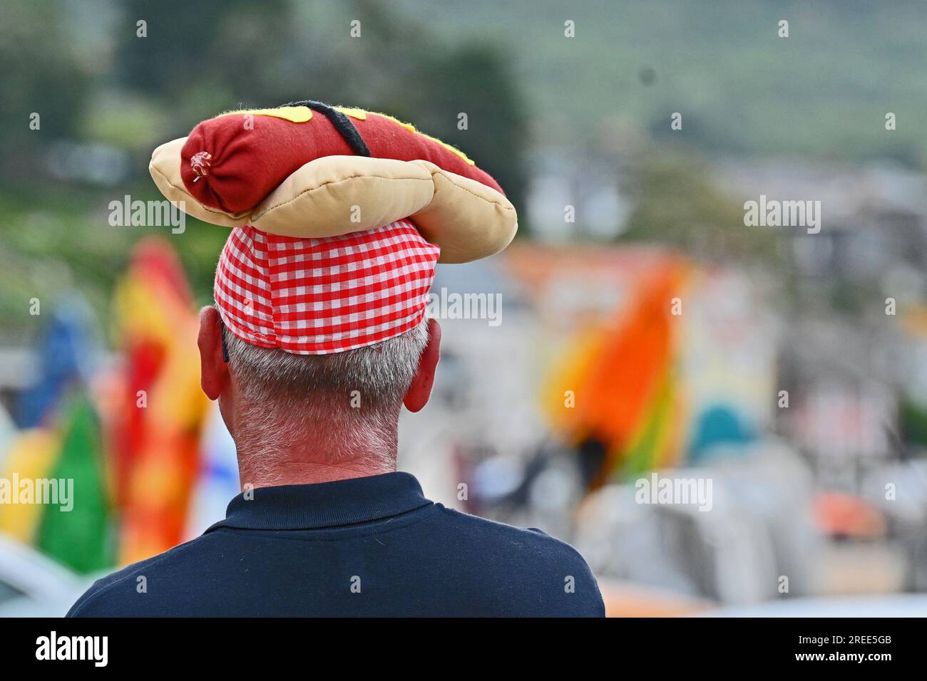 Lyme Regis, Großbritannien. 27. Juli 2023. An einem warmen und feuchten Nachmittag wurde Dave, ein Crewmitglied der RNLI, mit einem Hotdog auf dem Kopf gesehen, der Hotdogs zum Verkauf rief und Geld für die RNLI-Rettungsbootwoche bei Lyme Regis East Devon sammelte. Bildnachweis: Robert Timoney/Alamy Live News Stockfoto