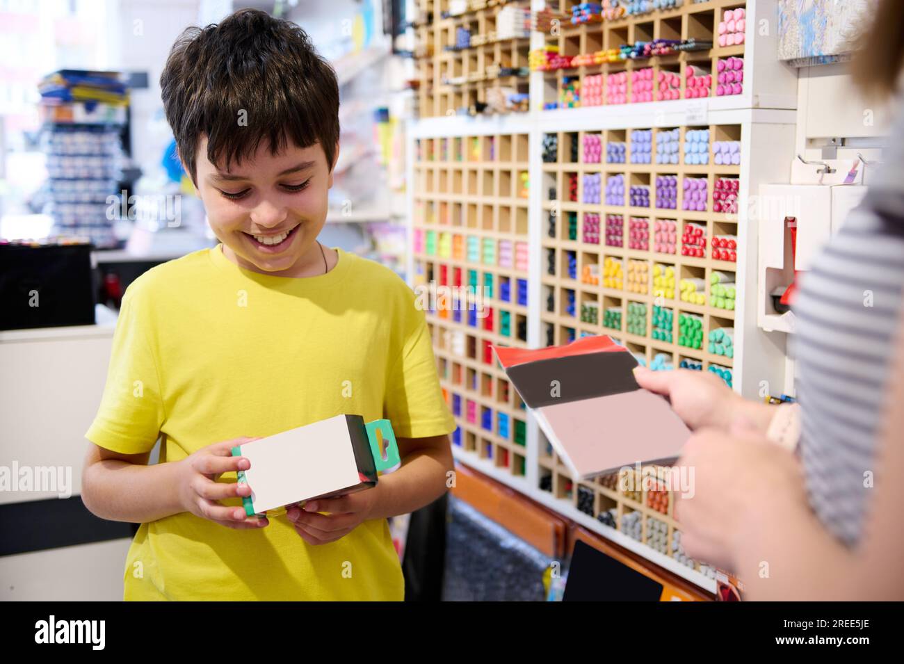 Der hübsche weiße Teenager-Schuljunge lächelt und kauft gern im Schreibwarenladen ein. Bürobedarf. Kreative Menschen. Hobby. Schöne Kunst. Bildungswesen Stockfoto