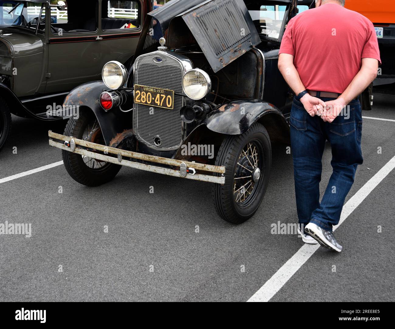Ein Besucher einer antiken und kundenspezifischen Automesse inspiziert ein nicht restauriertes Coupé des Modells A Ford aus dem Jahr 1930. Stockfoto