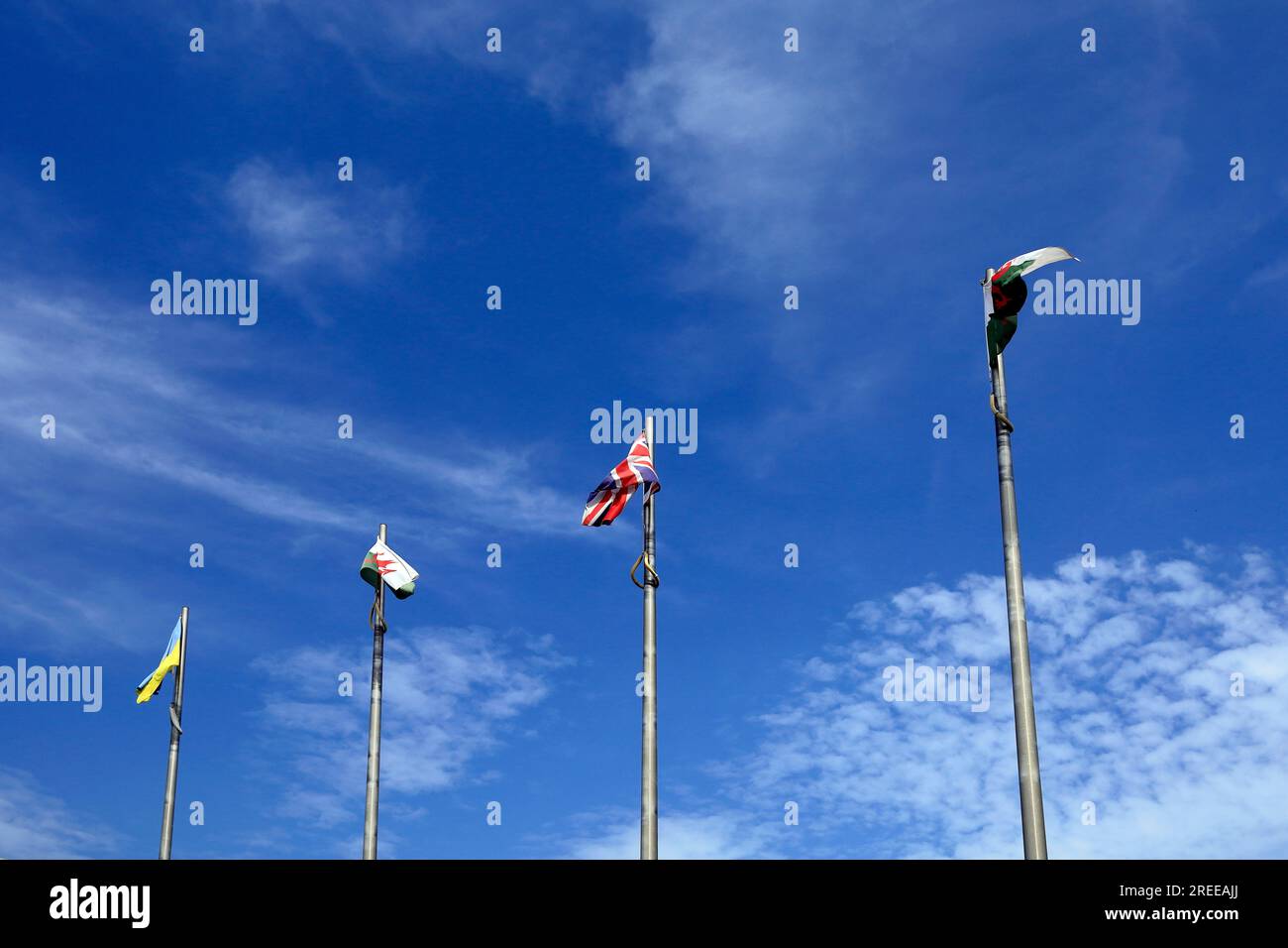 Ukrainische Flagge und walisische Flaggen auf Flaggenmasten vor blauem Himmel, Juli 2023. Cardiff Stockfoto