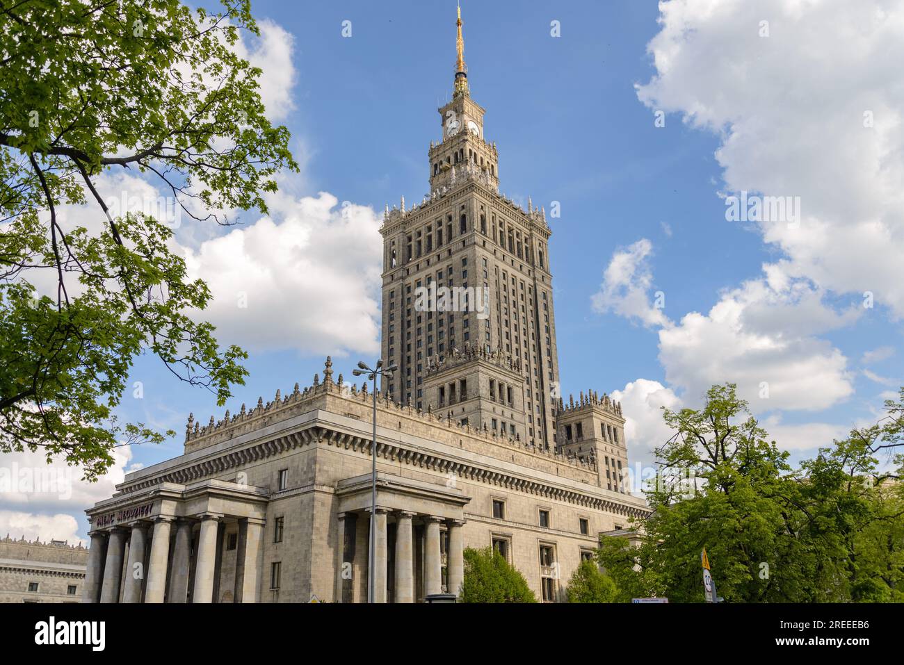 Von außen bietet der Park einen sonnigen Blick auf den Palast der Kultur und Wissenschaft und den Hintergrund des berühmten stalinistischen Architekturturturturturms in Warschau. Stockfoto