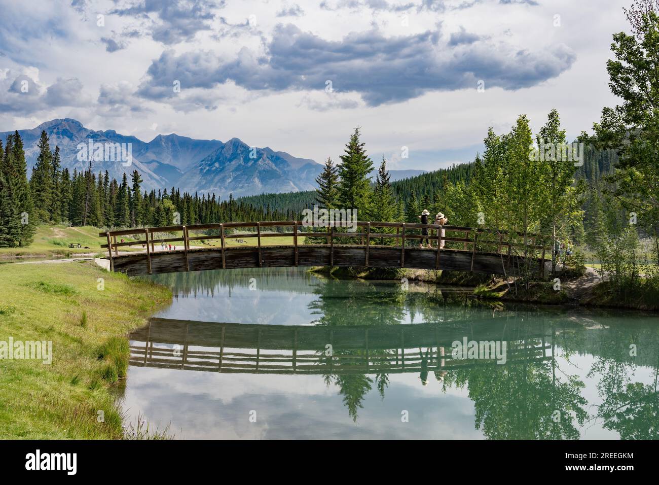 Rauch aus den zahlreichen wilden Feuer verursacht Dunst über den Rocky Mountains im Hintergrund. Fußgängerbrücke über Cascade Pond, Banff, Alberta, Kanada Stockfoto