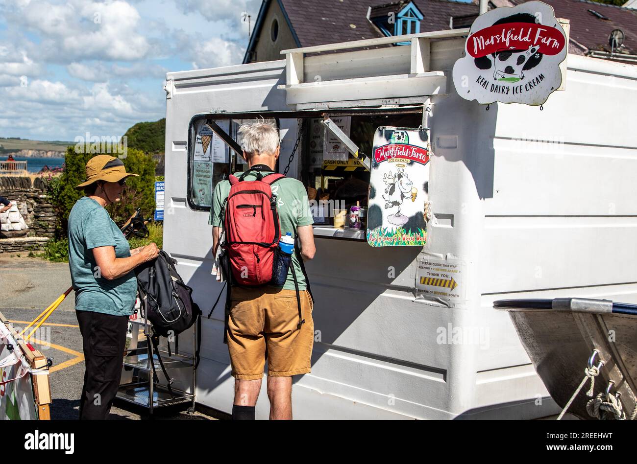 Touristen, die Eiscreme in Cwm-Yr-Eglwys Pembrokeshire Wales UK kaufen Stockfoto