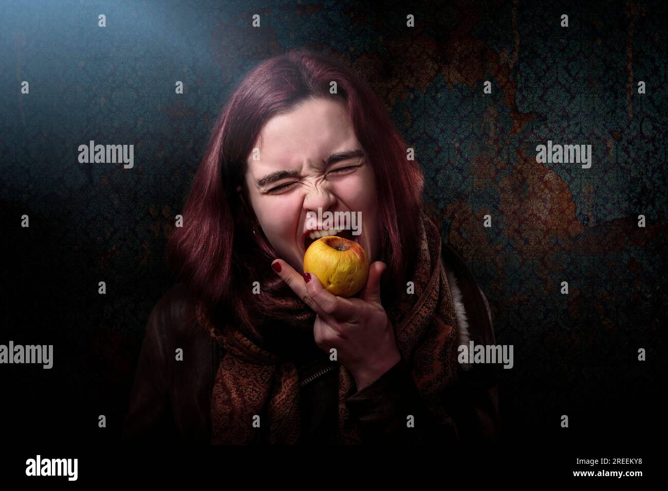 Verzweifelte Frau beißt in einen alten Apfel Stockfoto