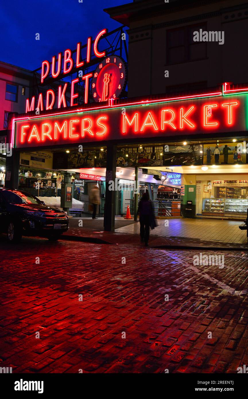 Die Neonlichter des Pike Place Market in Seattle spiegeln sich in den regnerischen Straßen wider Stockfoto