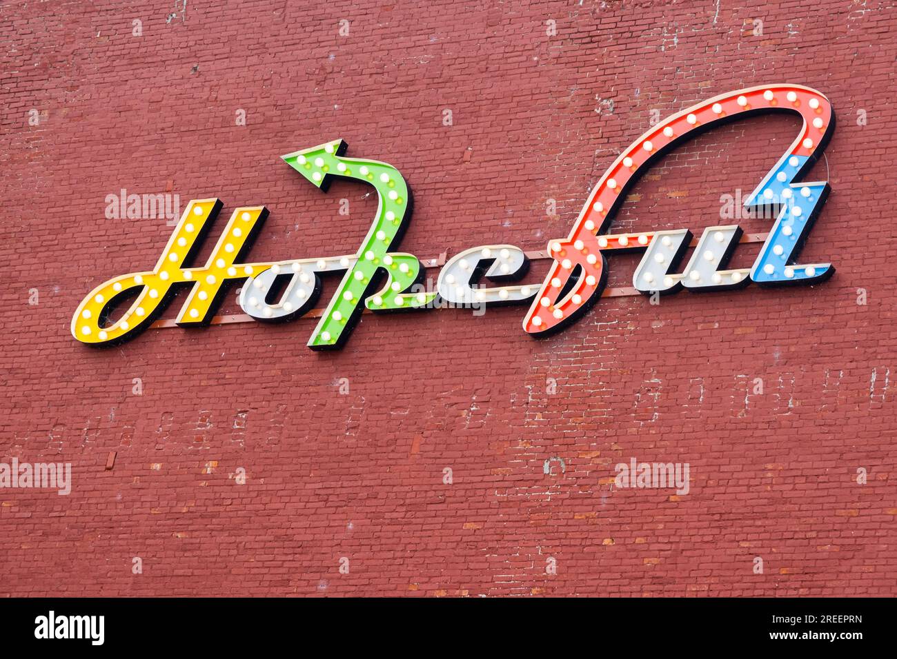 Hoffnungsvolle positive Inspiration Schild an der Seite eines roten Ziegelgebäudes Stockfoto