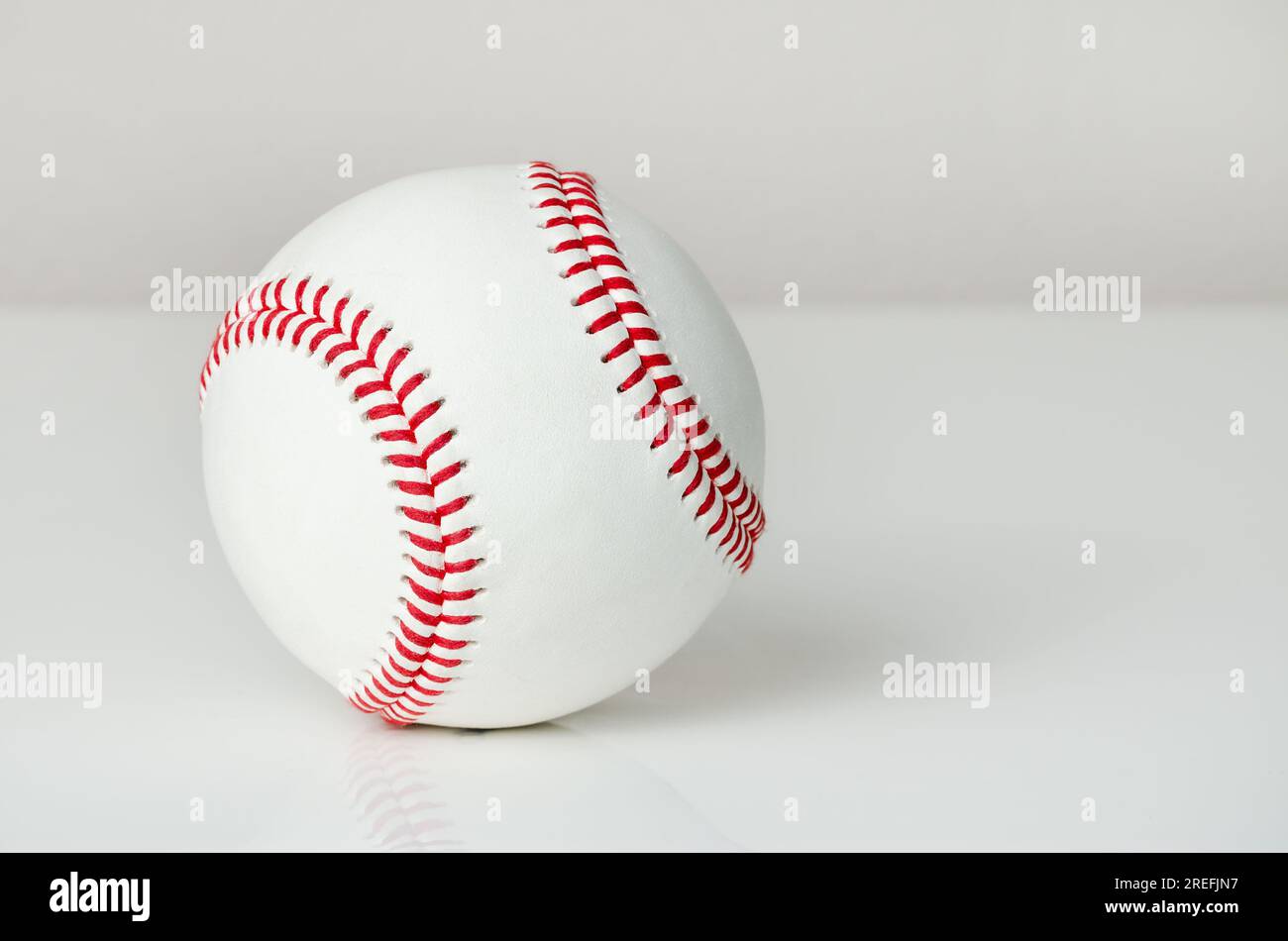 Nahaufnahme eines weißen Baseballballs mit roten Nähten auf weißem Hintergrund Stockfoto